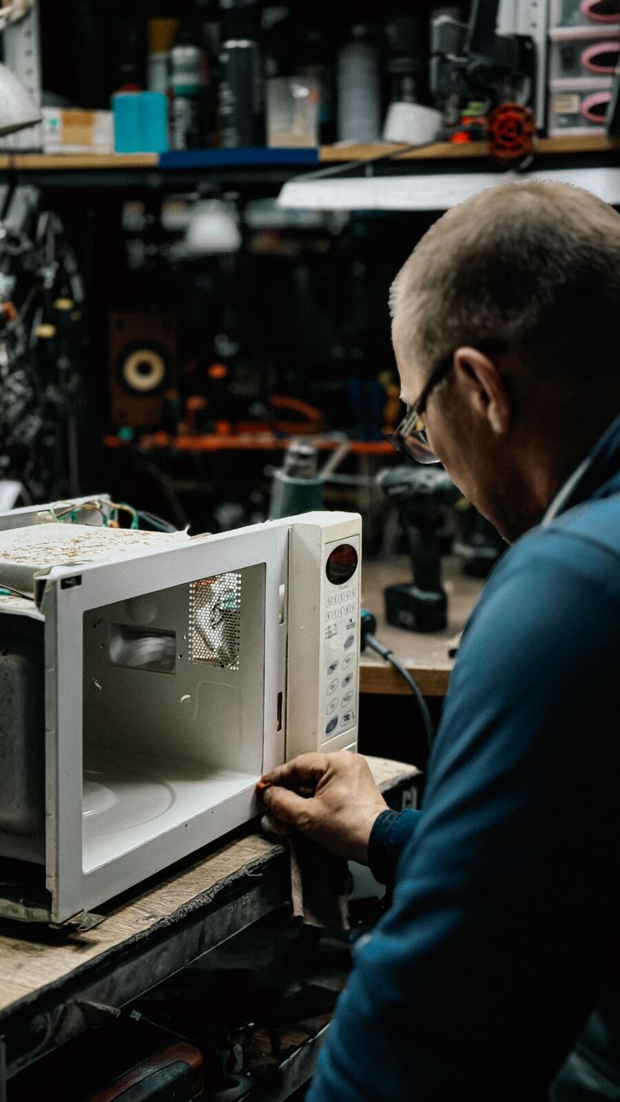 Technician examining the inside of a microwave oven